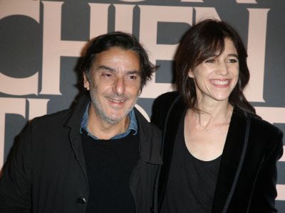 Both Charlotte Gainsbourg and Yvan Attal are wearing all black in the picture as they are posing for the cameras at an event.